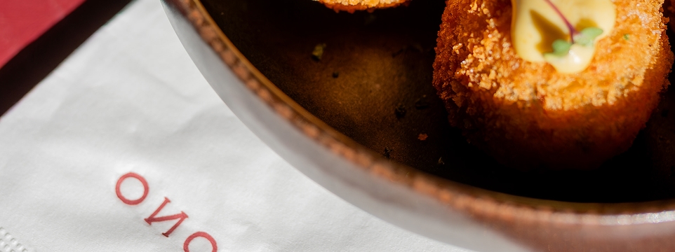 Bolinho dourado servido em uma travessa, sobre um guardanapo branco.